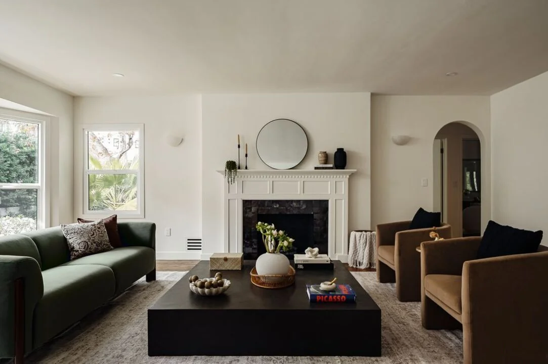 Canyon House living room with a fireplace, green sofa, and garden windows