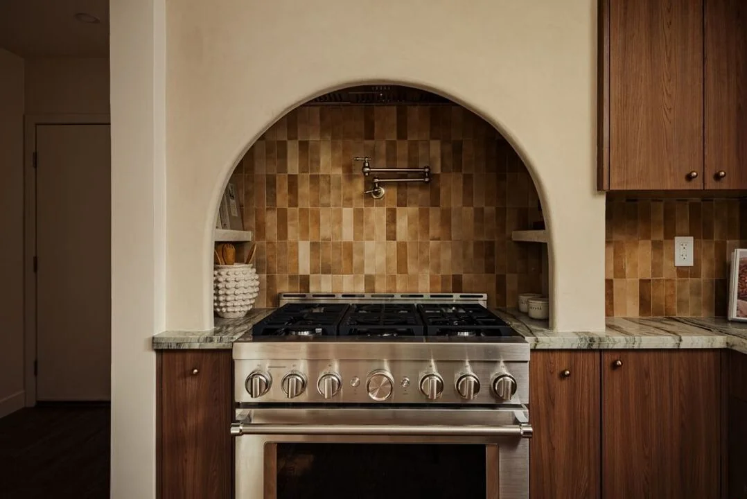 Warm tile and wood cabinetry frame an arched alcove above the Canyon House kitchen range