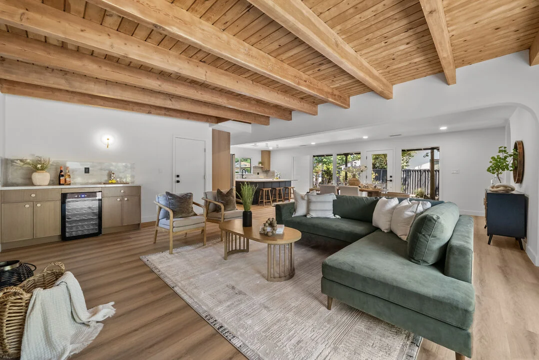 Timber House living room with exposed timber ceilings and a green sofa