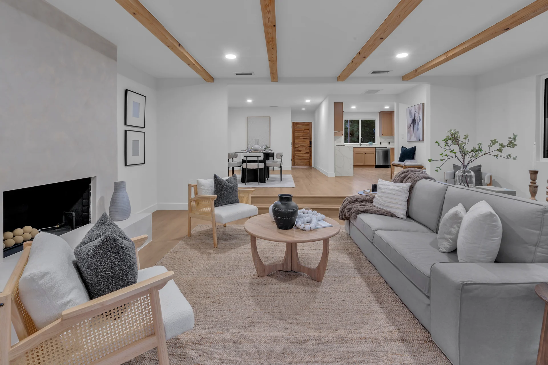 The Haven living room with timber beams, a fireplace, and soft seating